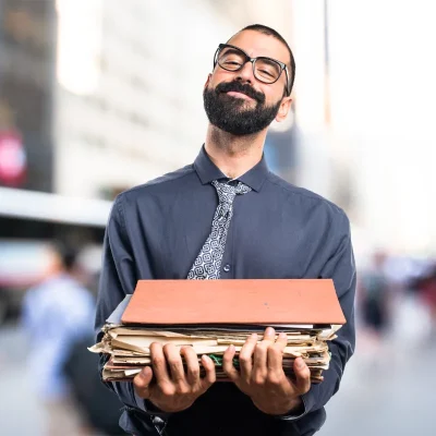 Profissional segurando arquivos, símbolo de livros de gestão.