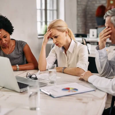 Reunião tensa com equipe preocupada em gerenciamento de crise.