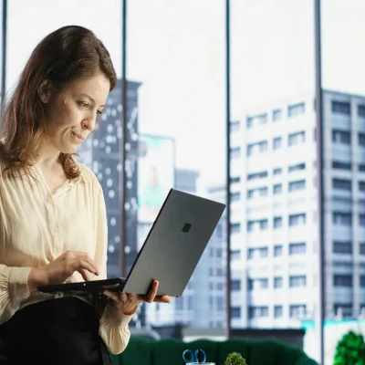 Administradora de condomínio com tecnologia no laptop