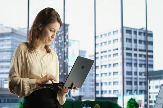 Administradora de condomínio com tecnologia no laptop