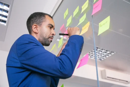 Profissional organizando tarefas em post-its na equipe