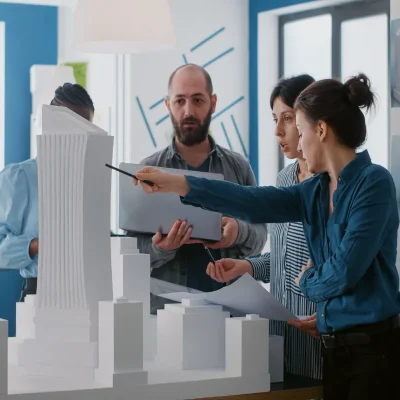 Equipe analisando maquete urbana com dicas de gestão em condomínios.
