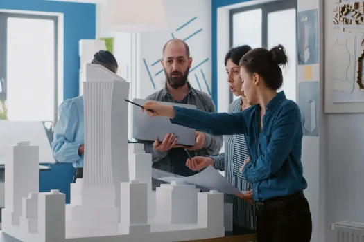 Equipe analisando maquete urbana com dicas de gestão em condomínios.