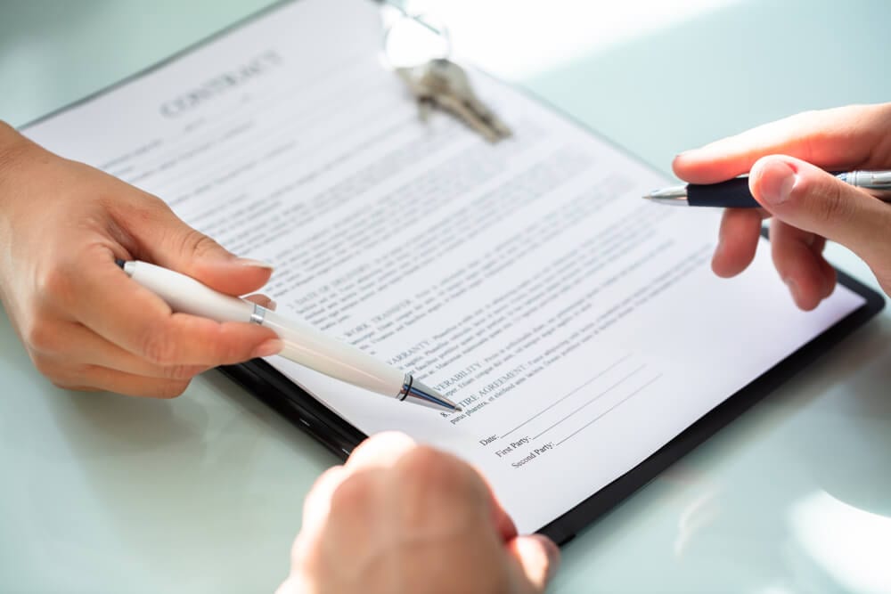 Responsabilidade do fiador em contrato de locação: como a imobiliária pode atuar Assinatura de contrato representando os documentos de responsabilidade do fiador em contrato de locação