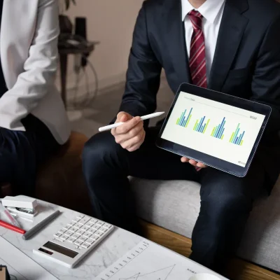 Consultor apresentando métricas de gestão condominial em tablet.