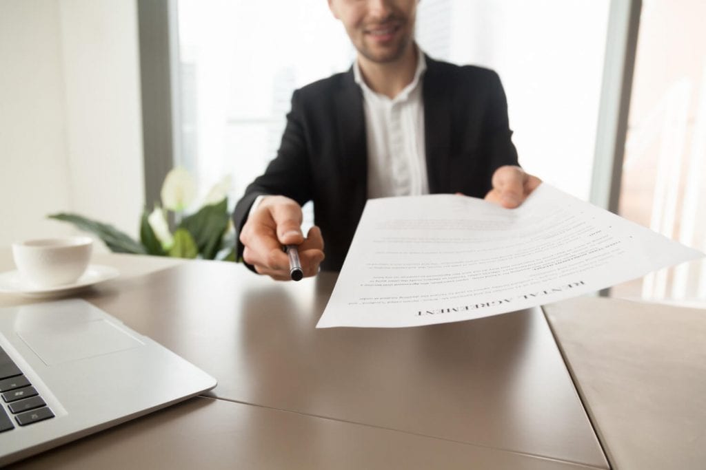 Homem entregando documento de reajuste contratual.