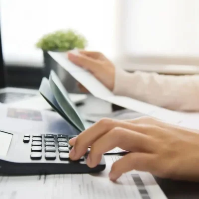 Pessoa com calculadora e documentos, termo de quitação de taxa condominial