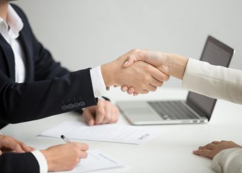 Employment handshake concept, female hr and successful woman candidate shaking hands getting hired ready to sign job contract concept, employer congratulating welcoming new worker, close up view