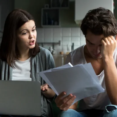 Casal discutindo contas em situação de multa de condomínio abusiva