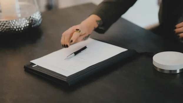 Pessoa assinando contrato de administradora de condomínio