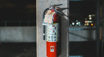 Extintor de incêndio preso à parede, representando regras da NR 23 atualizada