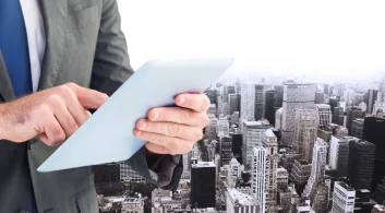 Close-up de um moderno edifício residencial branco com várias varandas, simbolizando um condomínio e a complexidade de unidades que influenciam no cálculo de quanto cobrar para administrar condomínio.