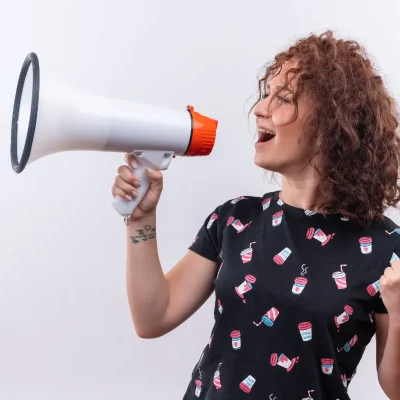Mulher segurando um megafone, representando a divulgação de comunicado aos condôminos de forma clara e centralizada.