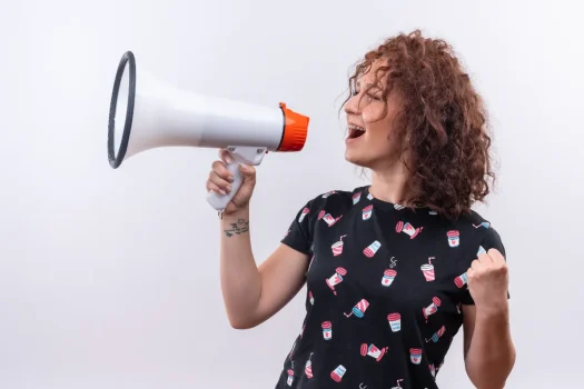 Mulher segurando um megafone, representando a divulgação de comunicado aos condôminos de forma clara e centralizada.