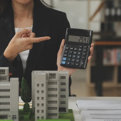 Mulher aponta calculadora ilustrando a tributação do condomínio