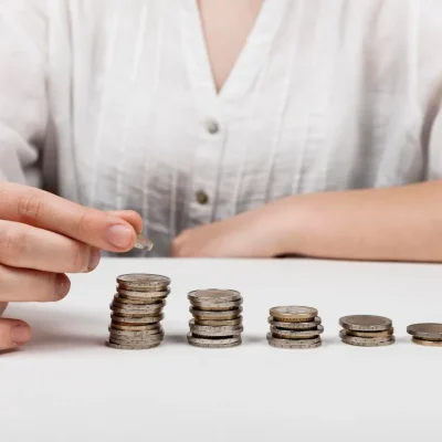 Pessoa contando moedas, representando falta de pagamento de condôminos inadimplentes