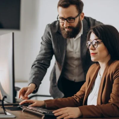 Profissionais no computador analisando o seguro empresarial para administradoras