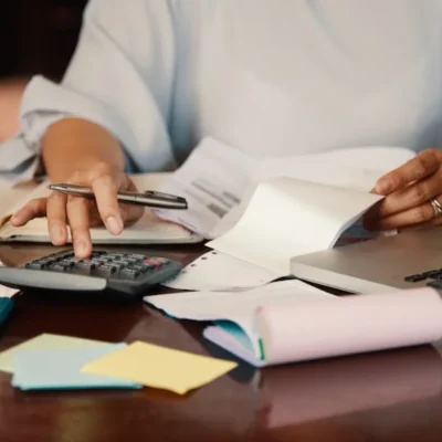 como criar régua de cobrança com profissional organizando documentos e calculando valores