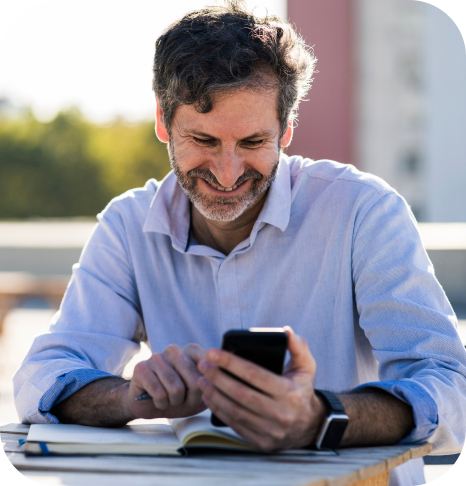 Homem sorrindo utilizando o celular